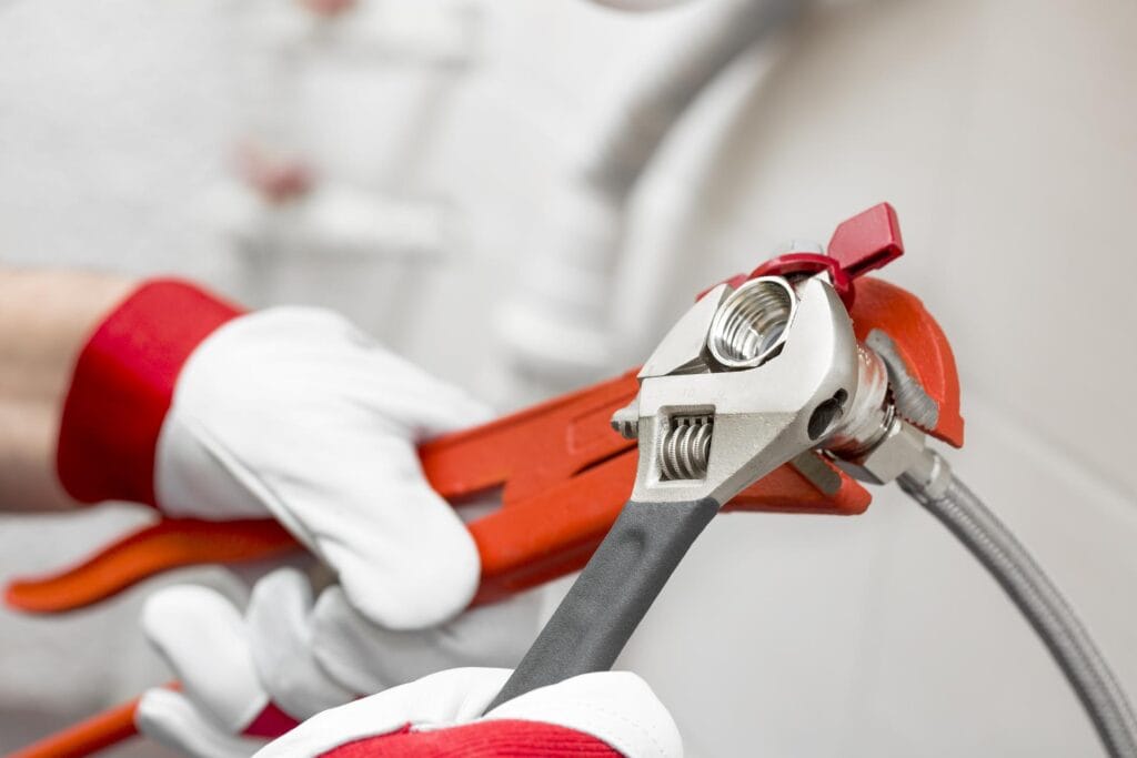 Plumber holding pipe wrenches for an emergency repair in Margate