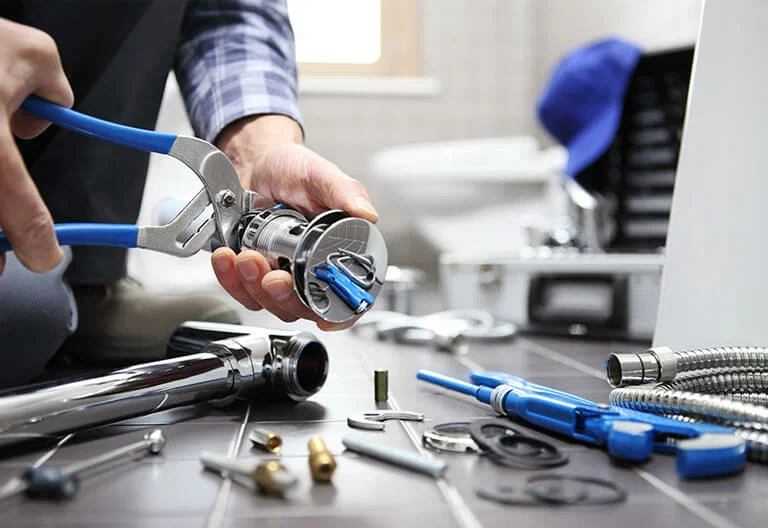Technician repairing a plumbing fixture with professional tools in Margate