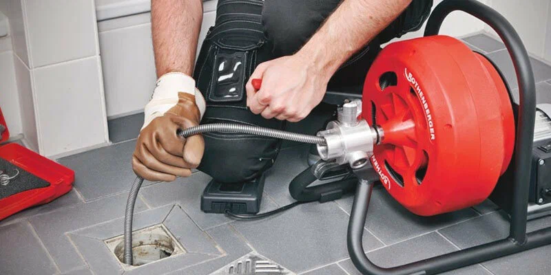 Plumber using a drain-cleaning machine in Margate
