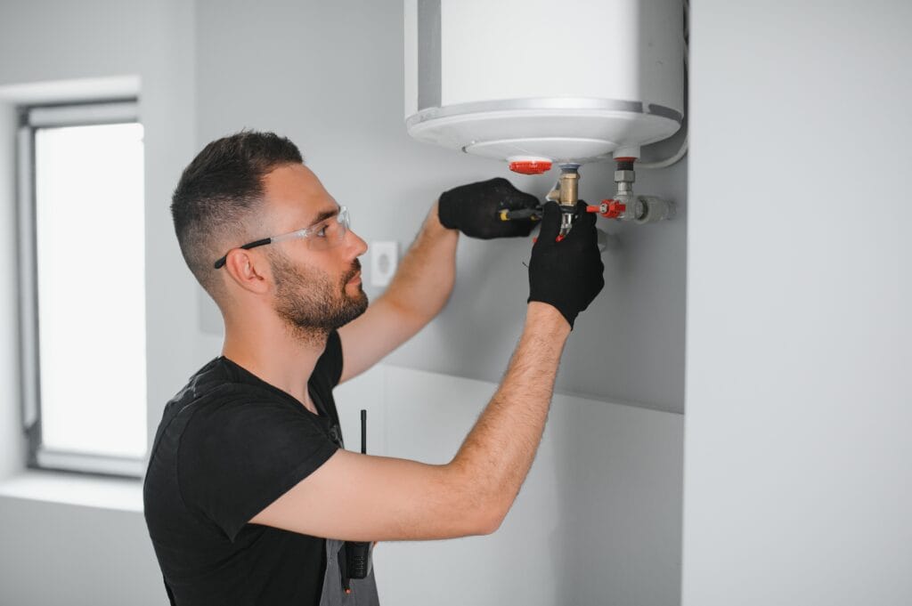 Technician performing water heater maintenance in Margate
