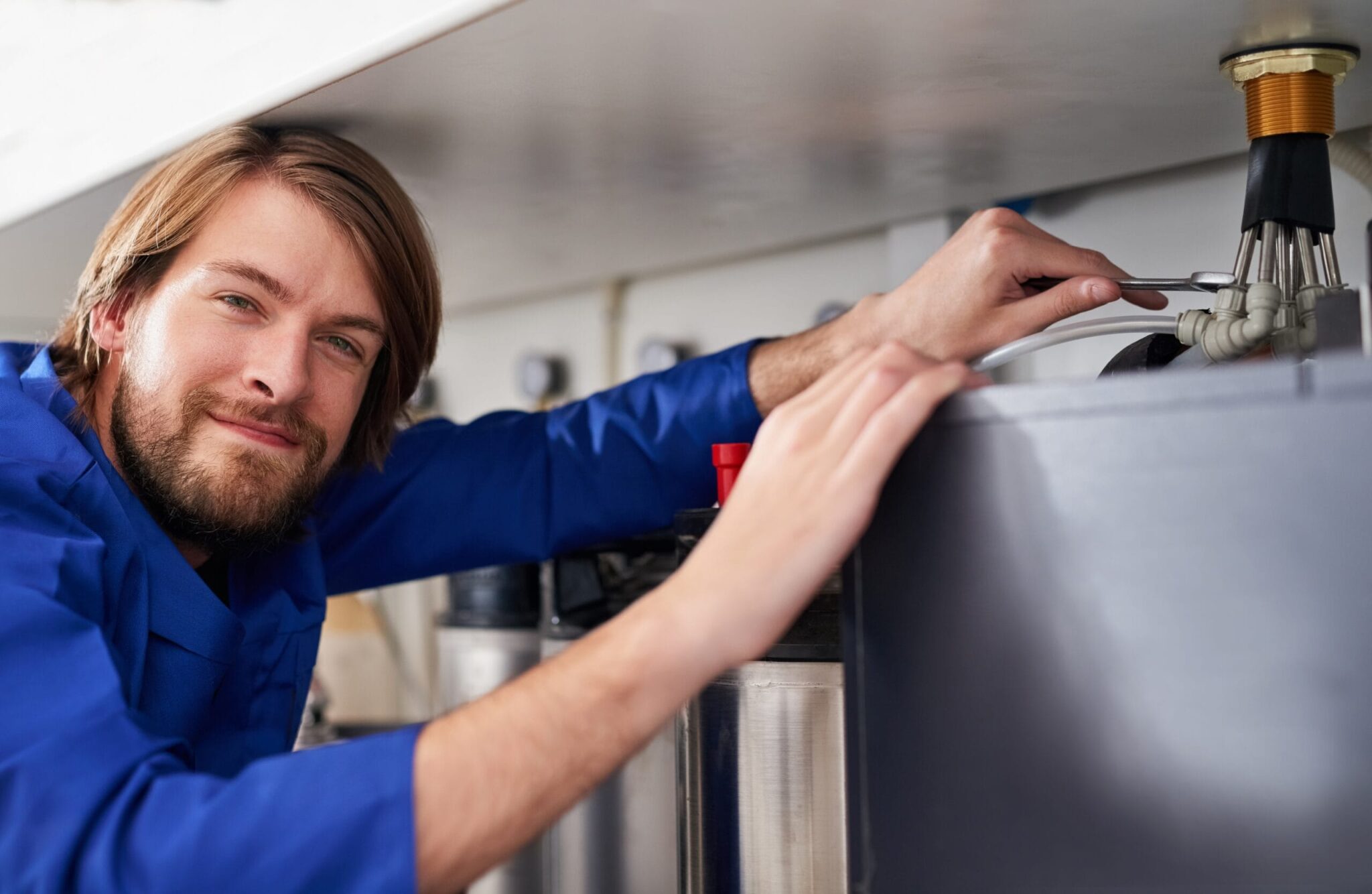 Technician servicing a residential water heater tank in Margate