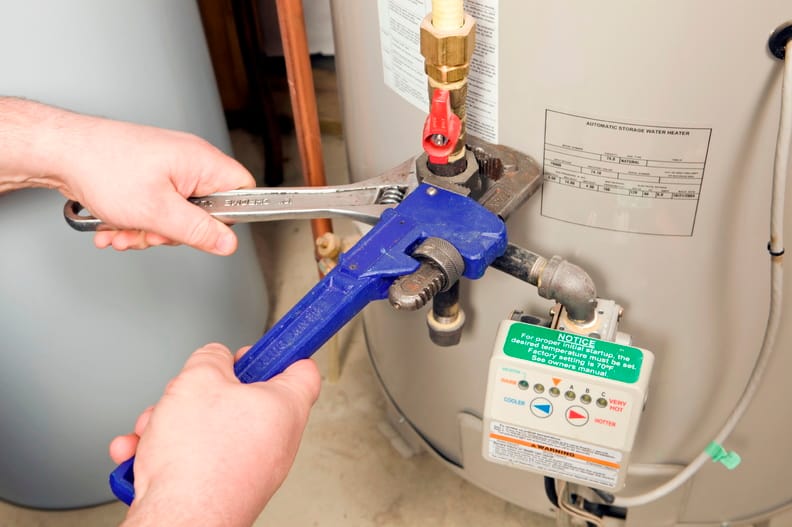 Plumber repairing a water heater valve in Margate